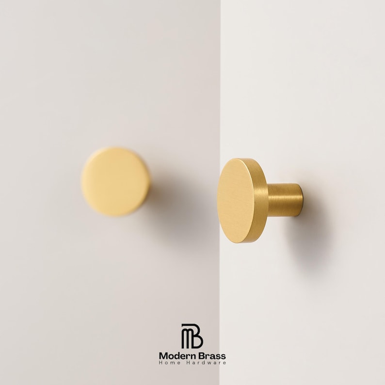 Close-up of modern gold circular knobs made of high-quality solid brass for furniture or cabinets.