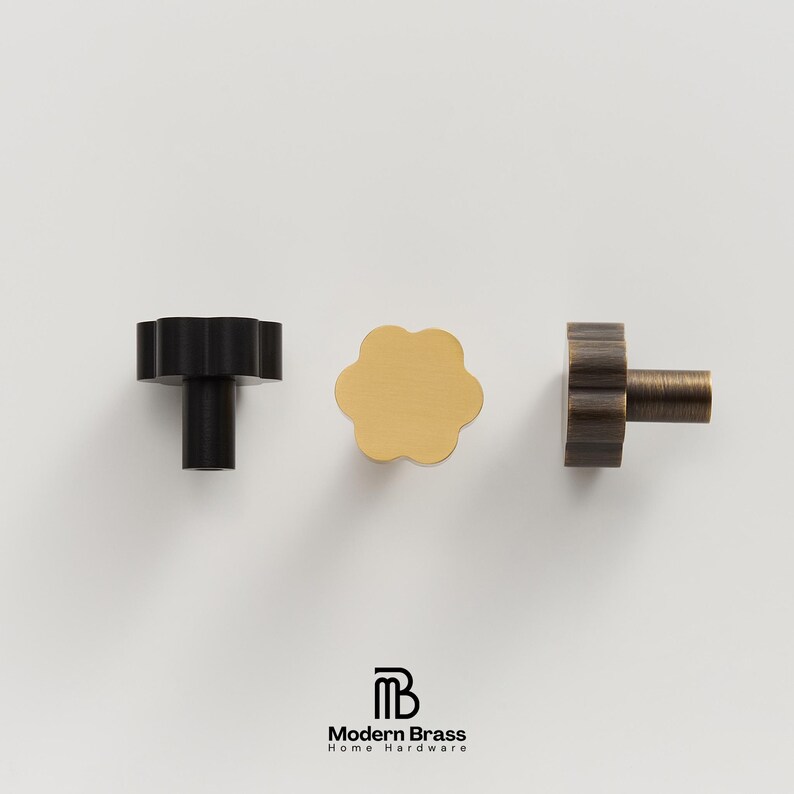 Extra-long gold furniture pulls featuring a tapered, tiered design in solid brushed brass.