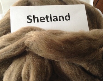 May include: A close-up of a pile of brown Shetland wool. The wool is soft and fluffy, and it is perfect for knitting or crocheting.