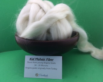 May include: White kid mohair fiber in a brown bowl, with a white label that reads "Kid Mohair Fiber Shorn from young Angora Goats 24-26 Microns Angora goats originally from Turkey Hearthside Fibers".