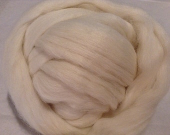 May include: A close-up of a large amount of white wool roving. The wool is soft and fluffy, and it is perfect for spinning or felting.