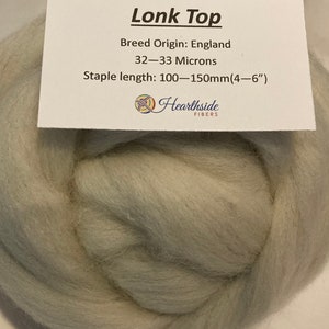 May include: A light gray Lonk Top wool fiber, a type of wool from England, with a staple length of 4-6 inches (100-150 mm). The label reads "Lonk Top", "Breed Origin: England", "32-33 Microns", "Staple length: 100-150mm(4-6")", and "Hearthside FIBERS".