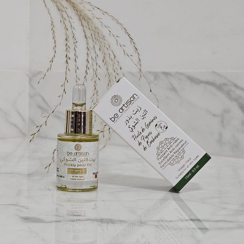 Pu&ograve; includere: Una bottiglia di vetro di "Prickly pear Oil" con un contagocce dorato e una scatola bianca. La scatola e la bottiglia hanno le parole "be artisan" e testo in pi&ugrave; lingue. La scatola recita "Huile de Graines de Figues de Barbarie".