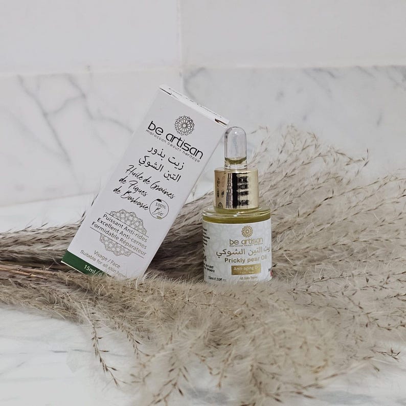 Pu&ograve; includere: Una bottiglia di olio di fico d'India "Be Artisan" con un contagocce, accanto a una scatola bianca con testo in pi&ugrave; lingue. L'olio &egrave; in una bottiglia di vetro trasparente con un tappo dorato.
