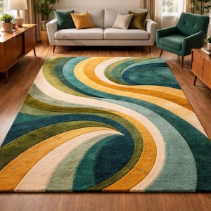 May include: A large area rug with a swirling, abstract design in shades of teal, yellow, green, and cream. The rug is placed on a hardwood floor and adds a pop of color to the room. The rug's dimensions are not visible.