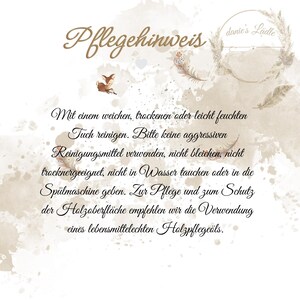May include: A decorative card with the text "Pflegehinweis" in elegant script. The card features a watercolor design with a deer, feathers, and text in German, providing care instructions for wooden surfaces.