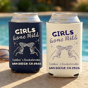 May include: Two drinks can coolers, one navy blue and one off-white, with the text "GIRLS Gone Mild". Below the text is an illustration of two hands toasting champagne flutes. The text "Sophia's Bachelorette SAN DIEGO, CA 2026" is printed below the illustration.