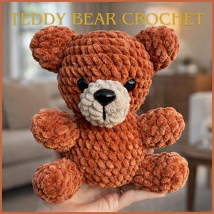 May include: A handmade, plush teddy bear in shades of brown, with a cream-colored muzzle and black eyes. The bear is crocheted with a textured yarn, and the text "TEDDY BEAR CROCHET" is displayed at the top of the image.