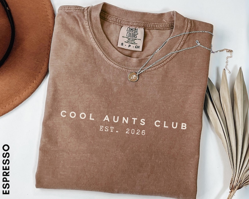 Minimalist Cool Aunts Club Est 2026 Comfort Colors shirt in dark neutral tone, modern aunt pregnancy announcement tee, trendy new aunt gift with clean typography aesthetic
