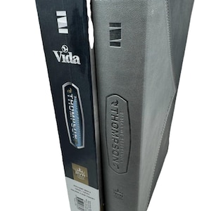 K&ouml;nnte beinhalten: Eine graue Bibel mit dem Text "THOMPSON BIBLIA DE REFERENCIA" und "Vida" auf dem Einband. Der Buchr&uuml;cken ist schwarz mit wei&szlig;em Text und dem Vida-Logo. Es ist eine Referenzausgabe.
