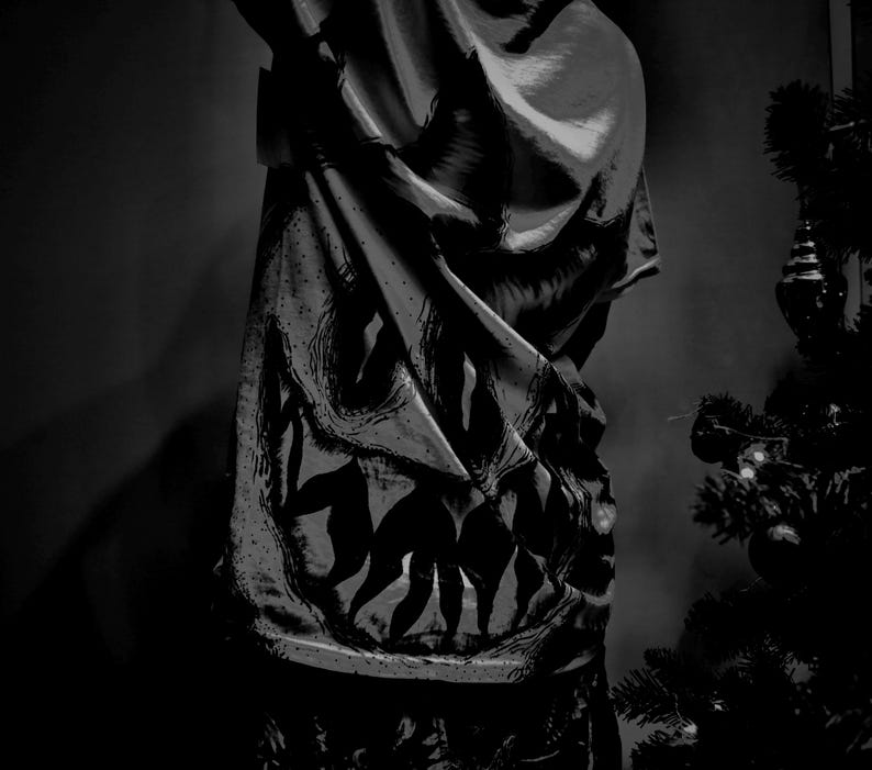 K&ouml;nnte beinhalten: Schwarz-wei&szlig; gemusterter Stoff mit einem gro&szlig;en, stilisierten Design. Der Stoff ist drapiert, mit sichtbaren Falten und Schatten. Im Hintergrund ist ein Weihnachtsbaum zu sehen.
