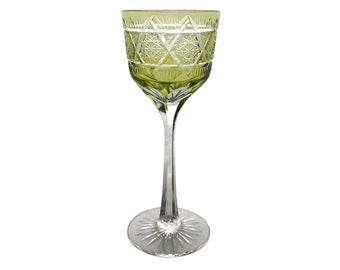 May include: A green glass wine glass with a cut glass design. The glass has a tall stem and a wide bowl.
