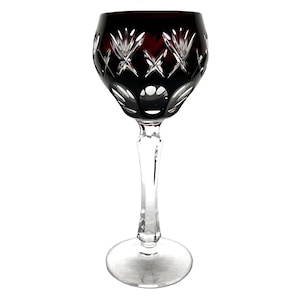 Könnte beinhalten: Ein dunkelrotes Weinglas mit geschliffenem Kristallmuster. Das Glas hat einen langen Stiel und eine runde Schale.
