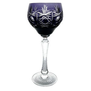 May include: A single, elegant wine glass with a deep purple bowl and a clear, textured stem and base. The bowl features intricate cut glass patterns. The glass is designed for serving wine.