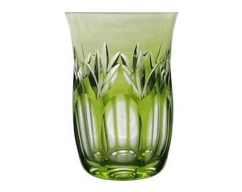 May include: A green-tinted glass with a cut-glass design. The glass has a flared top and a detailed pattern of vertical lines and leaf-like shapes. The overall aesthetic is elegant and decorative, suitable for serving beverages.