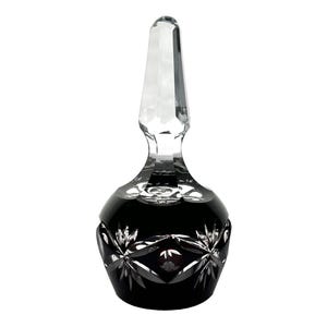 May include: A black crystal bottle stopper with a clear crystal top. The stopper has a decorative cut design.