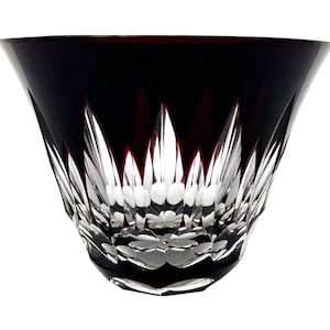 Könnte beinhalten: Ein rubinrotes Kristallglas mit einem breiten, ausgestellten Kelch. Der obere Teil ist tiefrot, geht in klare, komplizierte Schnitte am Boden über. Das Glas hat ein facettiertes Design, das Licht reflektiert.