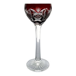 Puede incluir: Una copa de vino con tallo de vidrio transparente con una copa roja de vidrio tallado. La copa tiene un patrón geométrico.