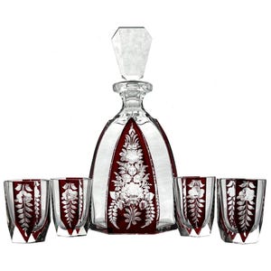 Könnte beinhalten: Ein Set aus fünf Kristallgläsern, darunter eine Karaffe mit rotem Sockel und geätzten Blumendesigns. Die Gläser sind klar mit geätzten Blumendesigns.