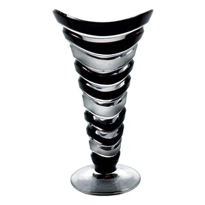 May include: A tall, black and silver glass vase with a unique, spiraled design. The vase has a wide base and a narrow opening.