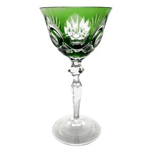 May include: A green glass wine goblet with a cut crystal design. The goblet has a tall stem and a wide bowl.