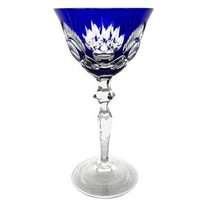 May include: A cobalt blue stemmed glass with a cut crystal design. The glass has a wide bowl and a tall, slender stem.