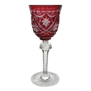 Może przedstawiać: Kryształowa kieliszek do wina w kolorze czerwonym z wygrawerowanym wzorem. Trzon jest przezroczysty, a podstawa jest przezroczysta z żebrowanym wzorem.
