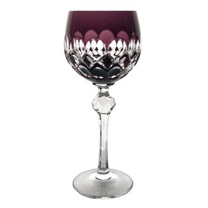 May include: A wine glass featuring a deep purple bowl with a clear cut-glass diamond pattern at the base. The stem is clear and includes a faceted hexagonal node, leading down to a circular clear glass base against a plain white background.