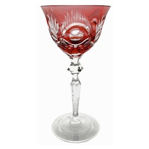 May include: A clear glass wine glass with a red, cut-glass bowl and a clear stem. The glass has a diamond-shaped base.