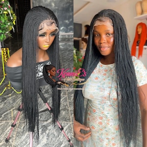 May include: A long, black micro-braided wig with a lace front is displayed on a mannequin and a person. The wig is styled with a natural hairline and long, flowing braids. The text "Kennie's Hair Boutique" is visible.