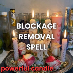 Könnte beinhalten: Eine Anordnung aus brennenden Kerzen, Rosen und Flaschen. Die zentralen Kerzen zeigen "BLOCKAGE REMOVAL SPELL" mit "powerful candle" unten. Die Kerzen sind weiß, und die Rosen sind rot und weiß.