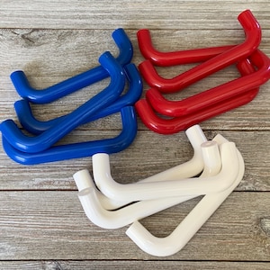 May include: A set of 12 plastic cabinet handles in red, white, and blue. The handles are in the shape of a D and have a smooth finish.