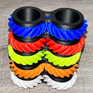 May include: A set of three ceramic mugs with a speckled, matte finish. The mugs are in shades of cream, light gray, and dark gray. Each mug has a simple, minimalist design, perfect for coffee or tea.