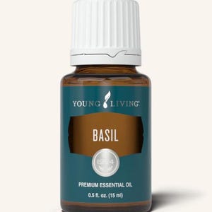 May include: A brown glass bottle of Young Living Basil premium essential oil. The bottle has a white cap and a teal label with the word "BASIL" in large white letters. The label also includes the text "1994" and "0.5 fl. oz. (15 ml)."