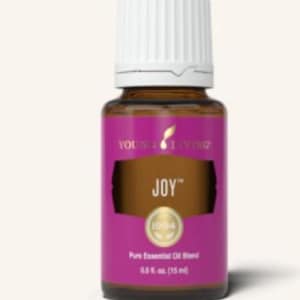 May include: A brown glass essential oil bottle with a white cap. The label is purple with the word "JOY" in gold. The bottle contains 0.5 fl. oz. (15 ml) of pure essential oil blend.