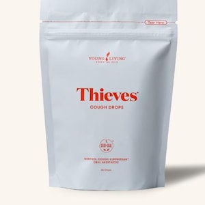 May include: A white pouch of Thieves Cough Drops. The brand name and product title are in red. The pouch also includes the text "MENTHOL COUGH SUPPRESSANT ORAL ANESTHETIC" and "30 Drops". The top of the pouch has a red dotted line with the words "Tear Here".