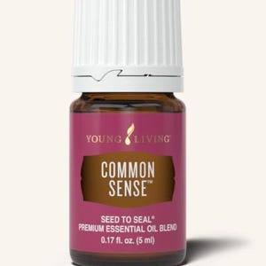 May include: A small brown glass bottle with a white cap, labeled "COMMON SENSE" in white text on a purple background. The bottle contains 0.17 fl. oz. (5 ml) of a premium essential oil blend. The brand name "YOUNG LIVING" is printed at the top.