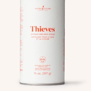 Può includere: Un contenitore cilindrico bianco di Thieves Kitchen and Bath Scrub. L'etichetta presenta il nome del marchio e i dettagli del prodotto in rosso, tra cui "14 oz. (397 g)". Il prodotto è per cucina e bagno.