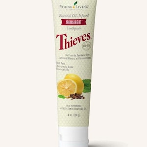 May include: A tube of Young Living Aromabright Thieves toothpaste. The tube is light green with text in red and black. The tube features a lemon and a half lemon, with cloves and mint leaves. The tube contains 4 oz (114 g) of toothpaste.