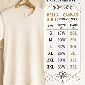 K&ouml;nnte beinhalten: Ein cremefarbenes T-Shirt mit Rundhalsausschnitt an einem goldenen Kleiderb&uuml;gel neben einer Bella + Canvas 3001 Gr&ouml;&szlig;entabelle. Die Tabelle listet die Gr&ouml;&szlig;en S bis 3XL mit Breiten- und L&auml;ngenma&szlig;en in Zoll auf, betitelt als Find Your Perfect Fit.