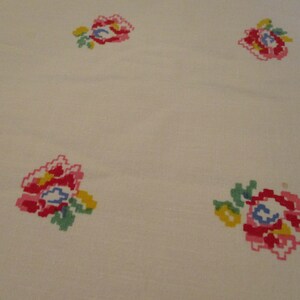 Pu&ograve; includere: Tessuto color crema con motivi floreali ricamati. I fiori sono realizzati in uno stile pixelato, con sfumature di rosso, rosa, giallo, blu e verde. Il disegno &egrave; distribuito uniformemente sul tessuto, creando un motivo ripetitivo.
