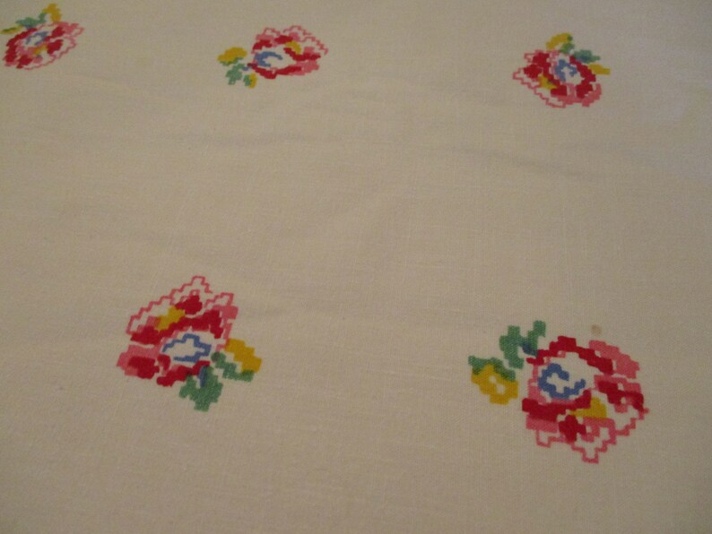 Pu&ograve; includere: Tessuto color crema con motivi floreali ricamati. I fiori sono realizzati in uno stile pixelato, con sfumature di rosso, rosa, giallo, blu e verde. Il disegno &egrave; distribuito uniformemente sul tessuto, creando un motivo ripetitivo.