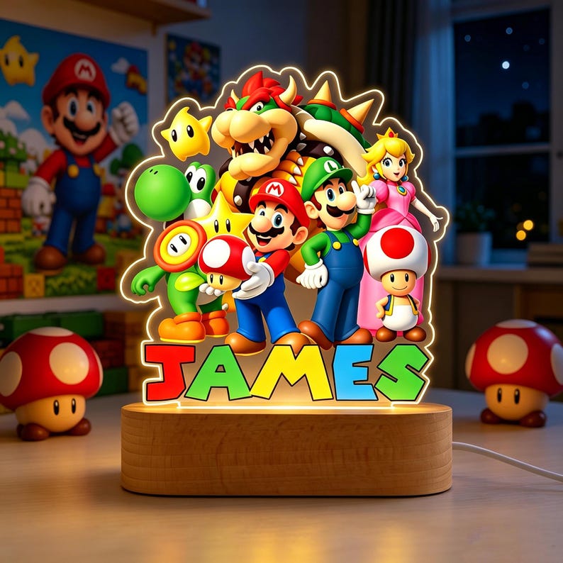 May include: A custom LED night light featuring a colorful acrylic cutout of Mario, Luigi, Princess Peach, Bowser, Yoshi, and Toad, with the name JAMES printed in bold, multi-colored letters at the base, mounted on a smooth, oval wooden stand.