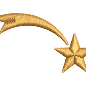 May include: A gold-coloured embroidered shooting star design featuring a five-pointed star with a curved, tapered trail extending from the top left. The embroidery consists of dense, textured golden thread stitches creating a dimensional effect.
