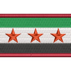 Peut inclure: Un écusson rectangulaire brodé présentant un motif tricolore horizontal avec des bandes verte, blanche et noire. Trois étoiles rouges à cinq branches sont centrées en ligne sur la bande blanche. L'écusson est bordé d'un épais contour rouge.