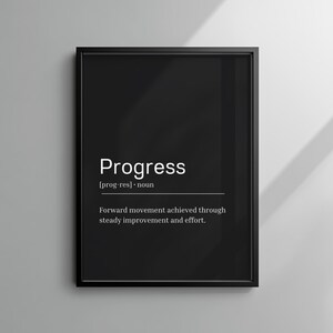 Puede incluir: Impresión enmarcada en negro con la palabra "Progress" en blanco, junto con su pronunciación y definición: "Movimiento hacia adelante logrado a través de una mejora y esfuerzo constantes."