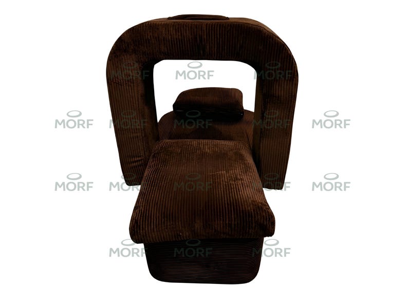 K&ouml;nnte beinhalten: Ein brauner Cord-Sessel mit einem einzigartigen, geschwungenen R&uuml;cken und Armlehnen. Der Stuhl hat eine rechteckige Sitzfl&auml;che und eine separate Kopfst&uuml;tze. Der Stoff hat eine vertikale Rippenstruktur. Das Wort "MORF" ist auf dem Stuhl aufgedruckt.