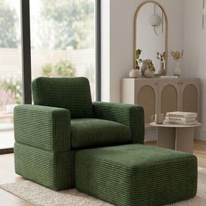 K&ouml;nnte beinhalten: Ein gr&uuml;ner Cord-Sessel mit passendem Hocker steht auf einem cremefarbenen Teppich. Der Sessel hat eine kastenf&ouml;rmige Form mit hoher R&uuml;ckenlehne und Armlehnen. Ein gro&szlig;es Fenster und ein dekorativer Spiegel sind im Hintergrund.