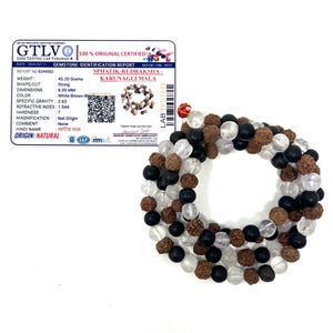 May include: A mala necklace featuring white, brown, and black beads. The beads are strung together, creating a circular design. A gemstone identification report is in the background, detailing the necklace's weight, dimensions, and colour.