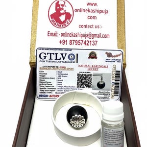 May include: A wooden box with a gold trim contains a black Karungali locket with a silver floral design, a testing certificate, and a small bottle. The text "MAHANT JI" and contact information are visible.